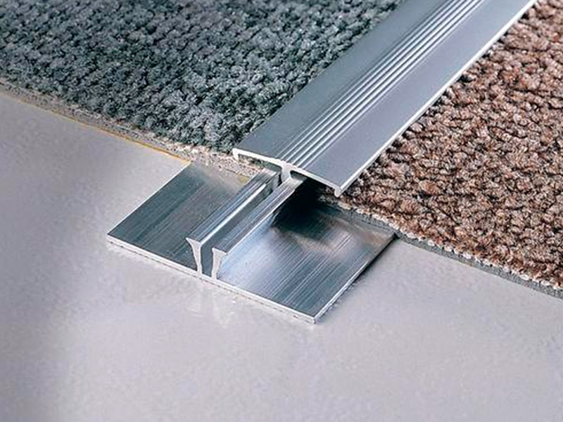 Comment s'appelle la bande métallique entre les tapis?